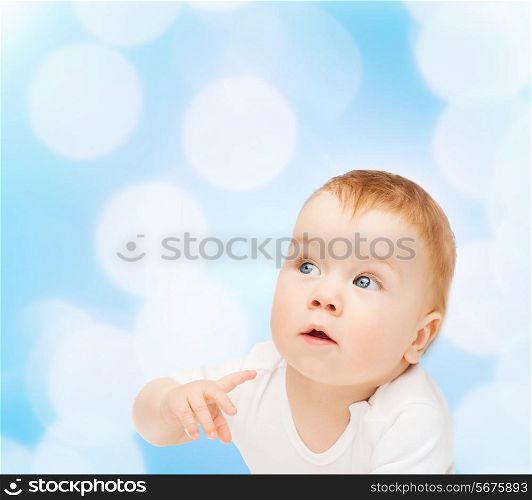 child and toddler concept - curious baby lying on floor and looking side