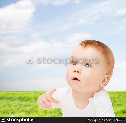 child and toddler concept - curious baby lying on floor and looking up