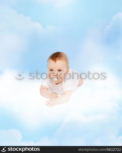 child and toddler concept - smiling baby lying on cloud with dummy in mouth