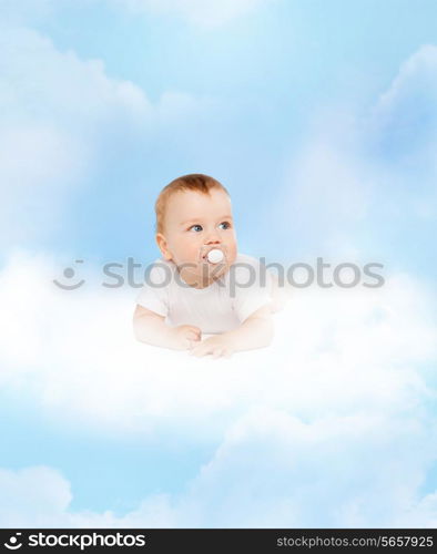 child and toddler concept - smiling baby lying on cloud with dummy in mouth