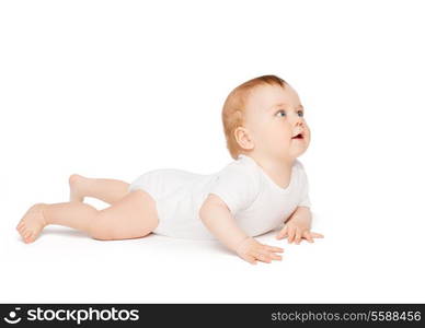 child and toddler concept - smiling baby lying on floor and looking up