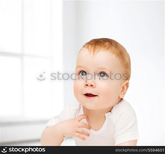 child and toddler concept - smiling baby lying on floor and looking up