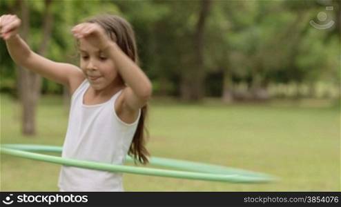 Child and toy, little girl having fun and playing with hula hoop outdoor. Copy space