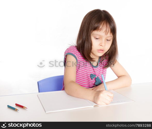 Child at desk with pencils and notebook