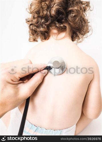Child at pediatrician with health check using stethoscope on back wearing diaper