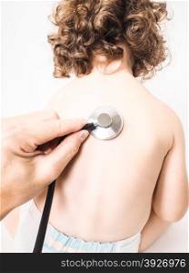 Child at pediatrician with health check using stethoscope on back wearing diaper