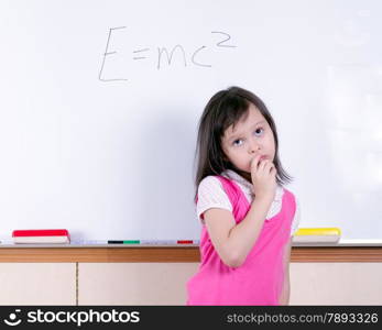 Child at whiteboard thinking about E=MC2