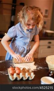 Child baking rolling out pastry in kitchen