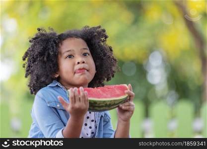 Child black girl happy with a slice of watermelon.