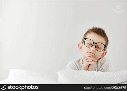 child boy in glasses praying in bedroom before going to bed. Empty space for text.. child boy in glasses praying in bedroom before going to bed. Empty space for text