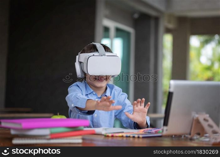 Child boy wears VR glasses (Virtual reality glasses). He is surprised by the content shown before his eyes by smarthphone in side connect by application.3D gadget technology.