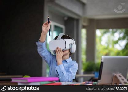 Child boy wears VR glasses (Virtual reality glasses).He is drawing on air follow visible image in side VR glassessmarthphone in side connect by application.3D gadget technology.