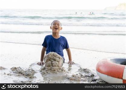 Child boys are playing the sea at the beach happily.