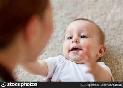 child, childhood, babyhood and motherhood concept - close up of happy little baby and mother