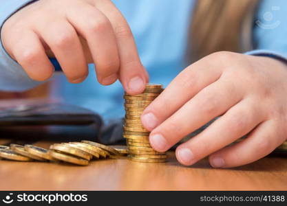 Child collects a stack of golden coins, close-up