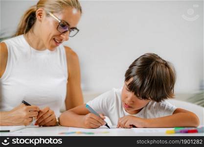 Child coloring shapes in a preschool assessment test.