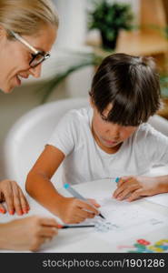 Child drawing shapes in a preschooler assessment test. Psychologist helping him.. Child drawing shapes in a preschooler assessment test.