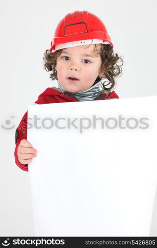 Child dressed as a builder with a blank board