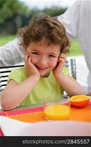 Child drinking a class of freshly squeezed orange juice