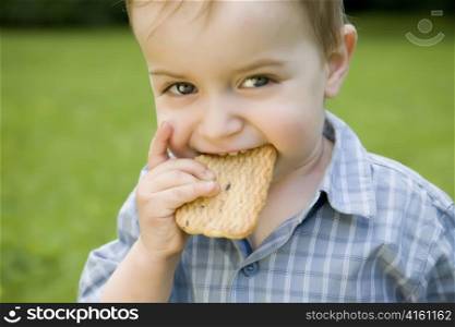 Child Eating Cookie On The Nature Background