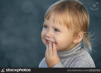 Child eats and smiles face portrait on blue bokeh background