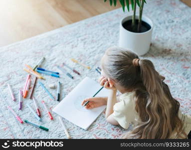 Child girl drawing with colorful pencils at home. Ecology concept, painting earth. 