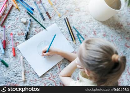 Child girl drawing with colorful pencils at home. Ecology concept, painting earth. 