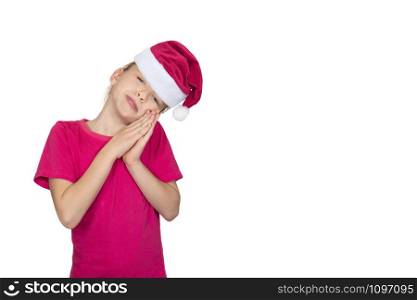 Child girl in santa hat and pink t-shirt smile and asks for something. Portrait of girl with long light brown hair in pink T-shirt isolated on white. Child girl in santa hat smile and pink t-shirt