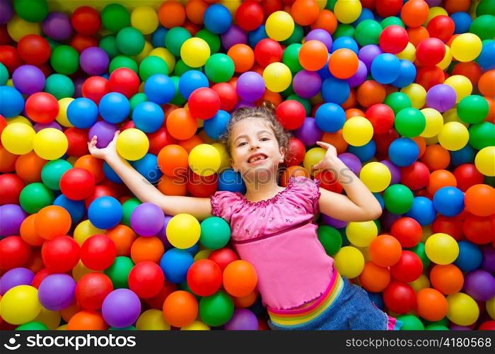 child girl playing on colorful balls playground high view