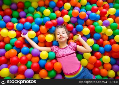 child girl playing on colorful balls playground high view