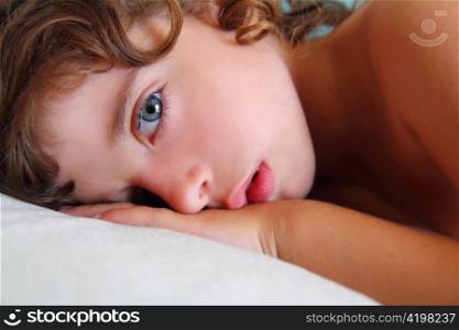 child girl relaxed on pillow looking camera with blue eyes