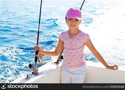 child girl sailing in fishing boat holding rod in blue sea