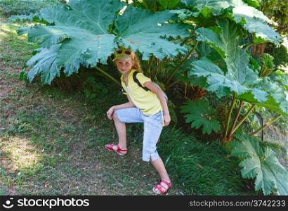 Child girl under the big leaf