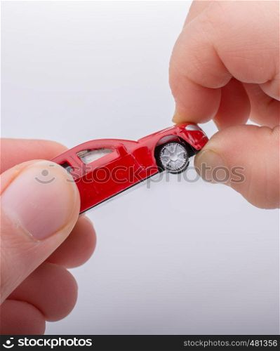 Child giving out toy car on white background