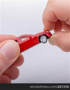 Child giving out toy car on white background