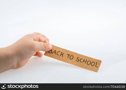 Child hand holding a back to school title on a notebook