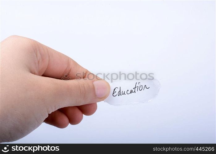 Child hand holding a education written a piece of torn paper