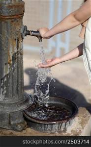 child hands under drinking fresh water tap on the beach on a bright Sunny day by the sea. High quality photo.. child hands under drinking fresh water tap on the beach on a bright Sunny day by the sea. High quality photo
