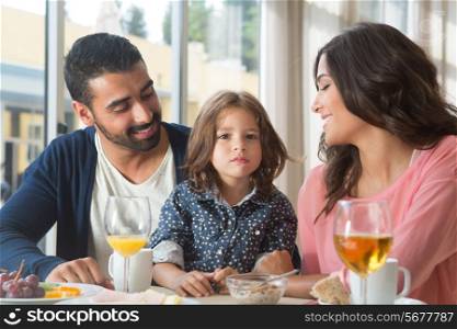 Child having breakfast with her mother and father