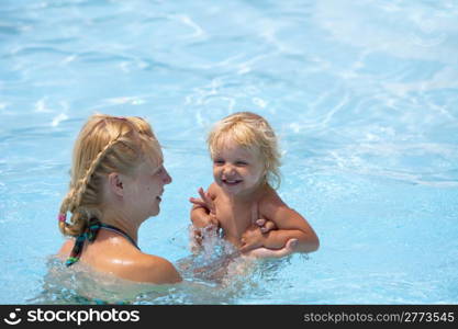 Child having fun in water with mom.