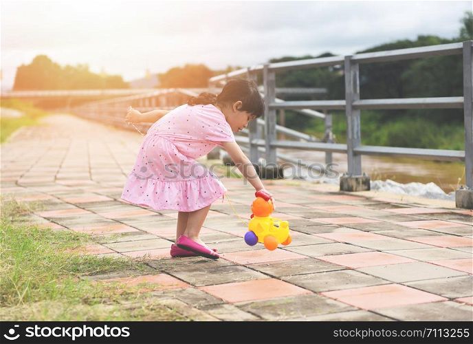 Child having fun playing outside Asian kid girl happy with toys in the park / International Children?s Day