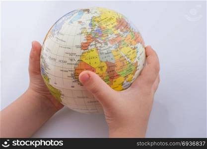 Child holding a globe in his hand on a white background