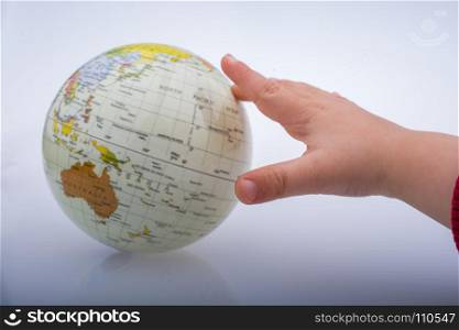 Child holding a globe in on a white background