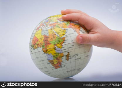 Child holding a globe in on a white background