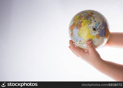 Child holding a globe in on a white background