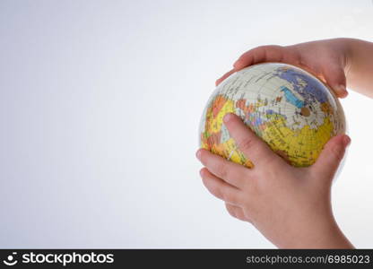 Child holding a globe in on a white background