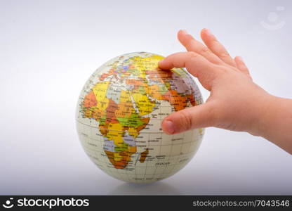 Child holding a globe in on a white background