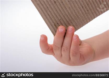 Child holding a piece of brown color cardboard