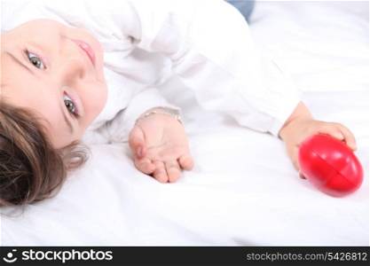 Child holding a plastic heart