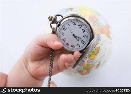 Child holding a pocket watch and a globe in his hand on a white background